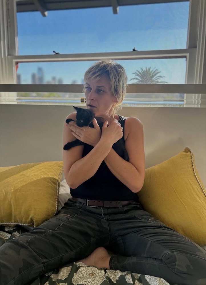 Jess at home holding a black cat
